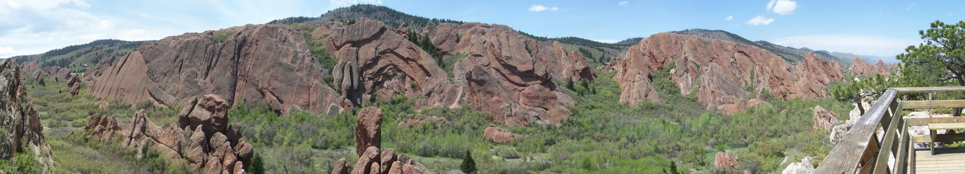 A wide view of red sandstone fins and green slopes at Roxborough State Park, seen from the Lyons Overlook